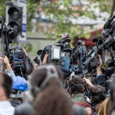 A large group of journalists and camera operators filming event. Image, Adobe. 